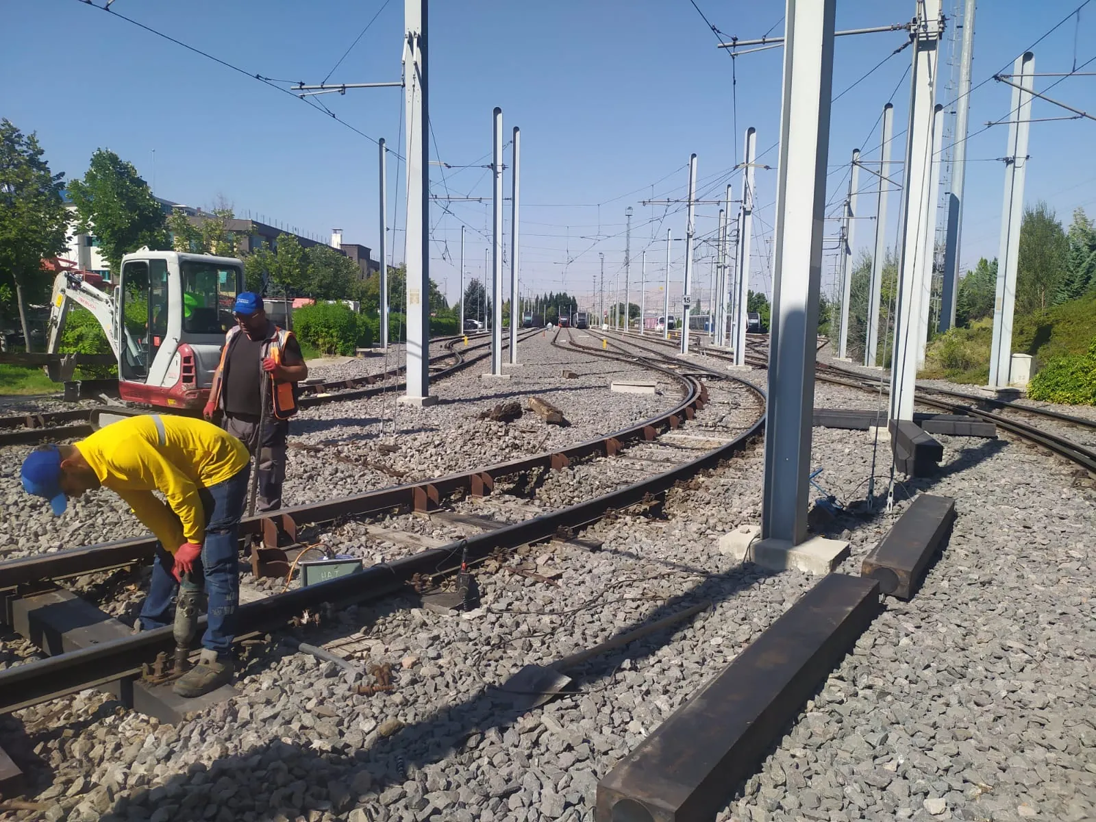 Sleeper replacement along a curve, with catenary masts